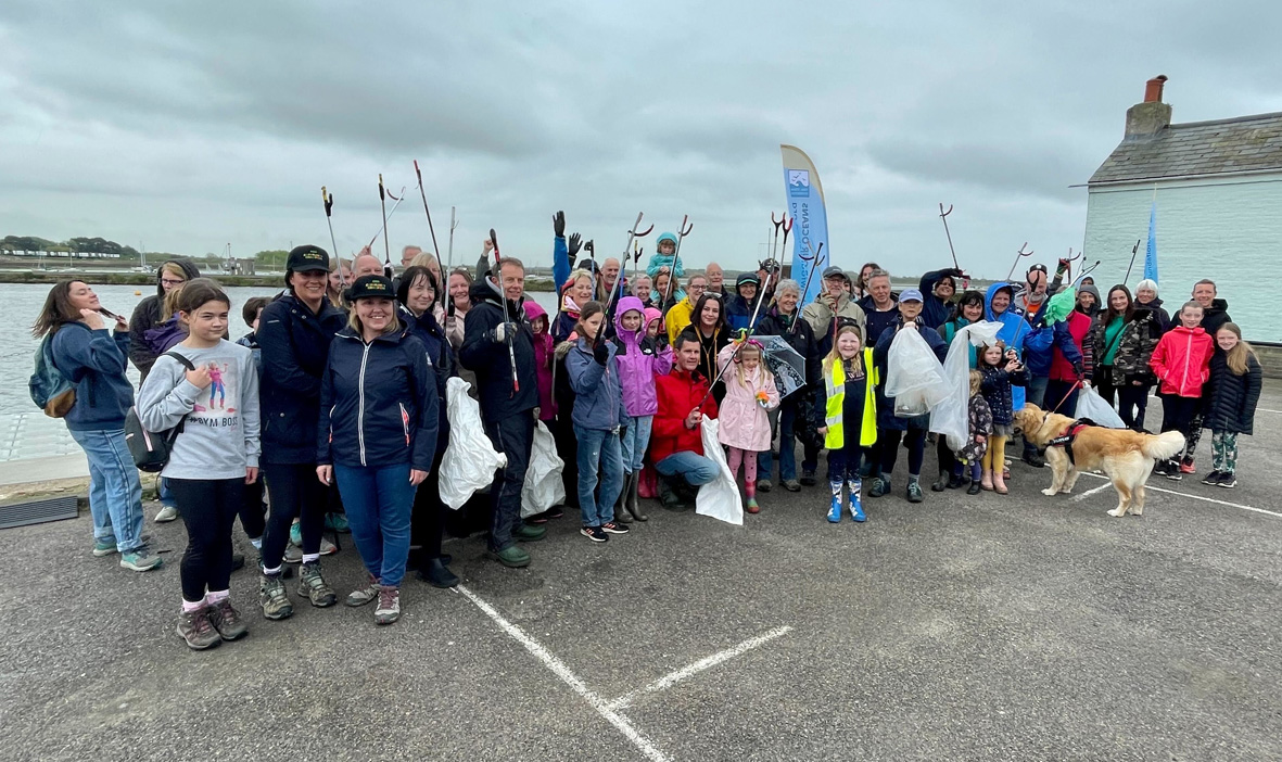 A photo of a group of volunteers with litter pickers at Emsworth in front of the sea on the 8th May for the Right Royal Clean Up
